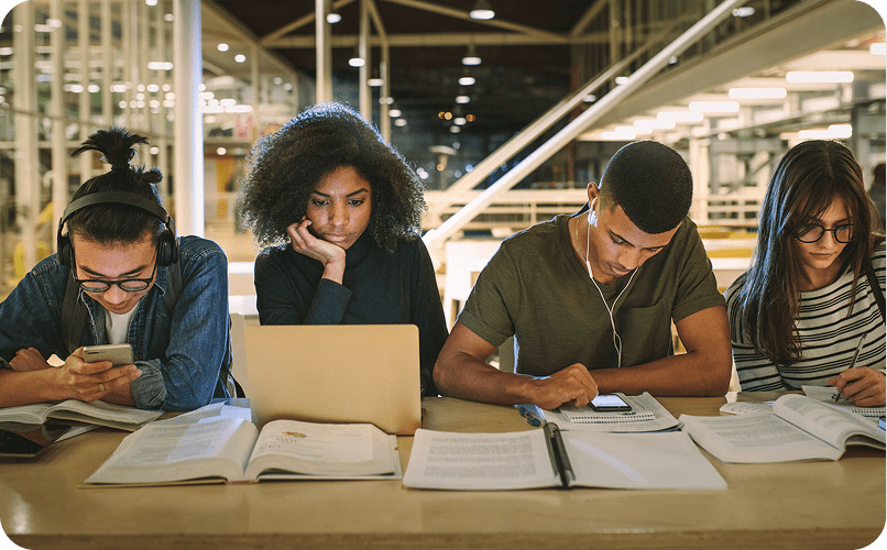 Students studying together at a library table.