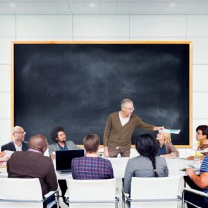 A teacher explains concepts to adult students in a classroom.