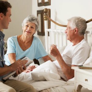 A young man talks with an elderly couple at home.